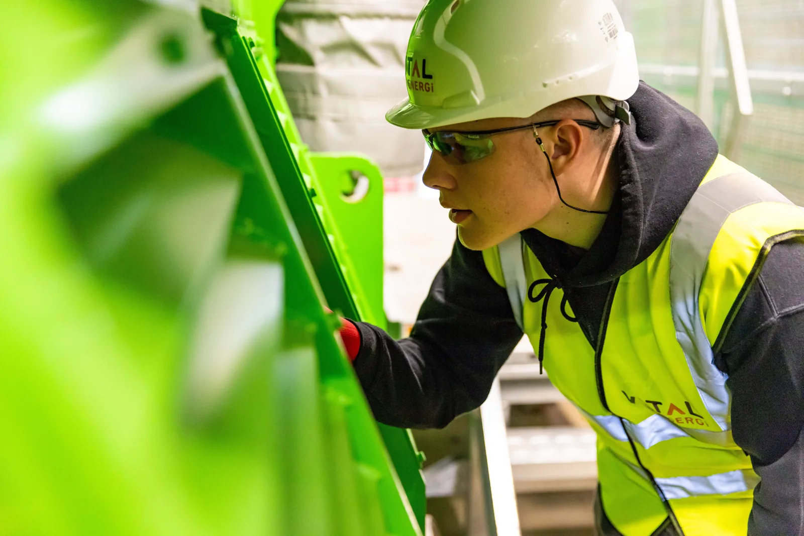 Profesional de ingeniería industrial inspeccionando maquinaria con equipo de seguridad